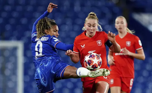 Chelsea's Catarina Macario, left, and FC Twente's Danique van Ginkel battle for the ball during the Women's Champions League group B match between Chelsea and FC Twente at the Stamford Bridge stadium in London, Wednesday, Dec. 11, 2024. (Zac Goodwin/PA via AP)