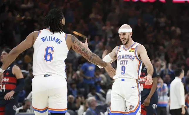 Oklahoma City Thunder guard Alex Caruso (9) and forward Jaylin Williams (6) celebrate after a basket during the first half of an NBA basketball game against the Washington Wizards, Monday, Dec. 23, 2024, in Oklahoma City. (AP Photo/Kyle Phillips)