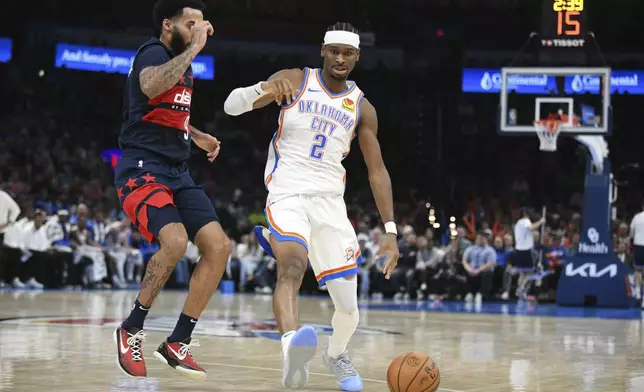 Oklahoma City Thunder guard Shai Gilgeous-Alexander (2) pushes past Washington Wizards forward Justin Champagnie during the second half of an NBA basketball game, Monday, Dec. 23, 2024, in Oklahoma City. (AP Photo/Kyle Phillips)