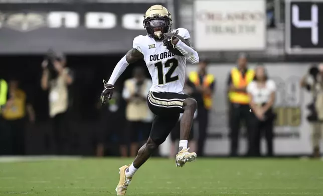 FILE - Colorado wide receiver Travis Hunter (12) runs after catching a pass during the first half of an NCAA college football game against Central Florida, Saturday, Sept. 28, 2024, in Orlando, Fla. (AP Photo/Phelan M. Ebenhack, File)