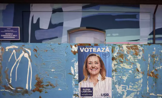 A poster of Elena Lasconi, presidential candidate who entered the presidential runoff in second position, is placed outside the closed voting station where Calin Georgescu, an independent candidate for president who won the first round of presidential elections, was supposed to vote, after Romania's Constitutional Court annulled the first round of presidential elections, in Mogosoaia, Romania, Sunday, Dec. 8, 2024. (AP Photo/Andreea Alexandru)