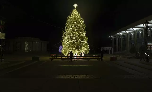 A man looks at the Christmas tree and Nativity scene on Payrow Plaza in Bethlehem, Pa., known as “Christmas City, USA,” on Sunday, Friday, Nov. 29, 2024. (AP Photo/Luis Andres Henao)