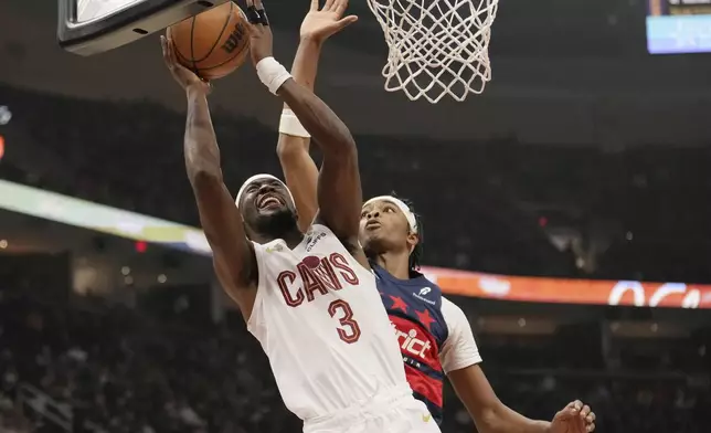 Cleveland Cavaliers guard Caris LeVert (3) shoots in front of Washington Wizards guard Bilal Coulibaly, right, in the first half of an NBA basketball game, Friday, Dec. 13, 2024, in Cleveland. (AP Photo/Sue Ogrocki)