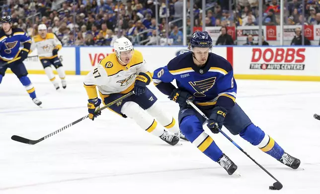 St. Louis Blues' Philip Broberg (6) controls the puck while under pressure from Nashville Predators' Michael McCarron (47) during the first period of an NHL hockey game Friday, Dec. 27, 2024, in St. Louis. (AP Photo/Scott Kane)