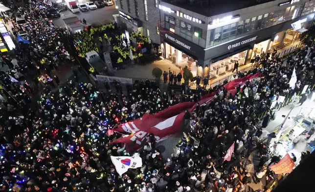 Participants stage a rally to demand South Korean President Yoon Suk Yeol's impeachment in front of the headquarters of the ruling People Power Party, in Seoul, South Korea, Monday, Dec. 9, 2024. (AP Photo/Ahnn Young-joon)