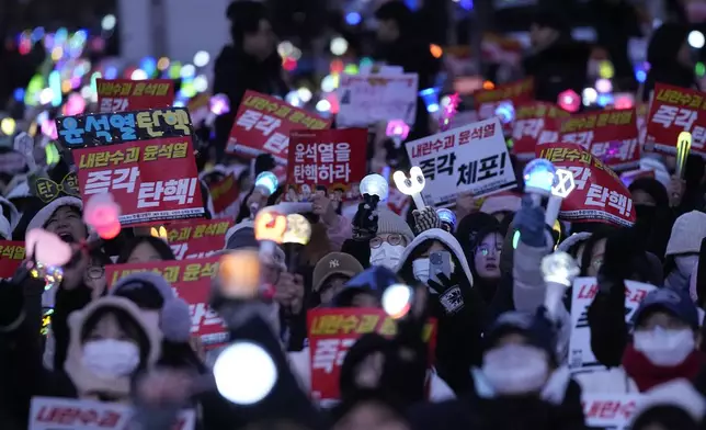 Participants attend a rally demanding South Korean President Yoon Suk Yeol's impeachment outside the National Assembly in Seoul, South Korea, Sunday, Dec. 8, 2024. The signs read "Impeach Yoon Suk Yeol." (AP Photo/Ahn Young-joon)
