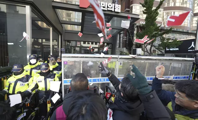 Members of the Korean Confederation of Trade Unions throw torn papers carrying the names of the ruling party's lawmakers who didn't vote at the impeachment motion last week, during a rally in front of the ruling People Power Party's head office in Seoul, South Korea, Monday, Dec. 9, 2024. (AP Photo/Lee Jin-man)