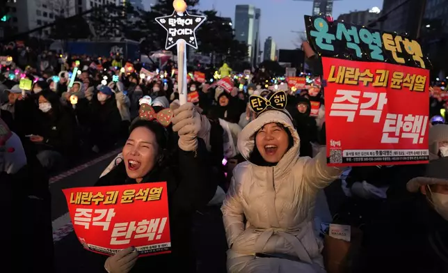 Participants shout slogans during a rally demanding South Korean President Yoon Suk Yeol's impeachment outside the National Assembly in Seoul, South Korea, Sunday, Dec. 8, 2024. The signs read "Impeach Yoon Suk Yeol." (AP Photo/Ahn Young-joon)