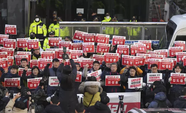 Members of the Korean Confederation of Trade Unions shout slogans as they hold signs carrying the names of the ruling party's lawmakers who didn't vote at the impeachment motion last week, during a rally in front of the ruling People Power Party's head office in Seoul, South Korea, Monday, Dec. 9, 2024. (AP Photo/Lee Jin-man)