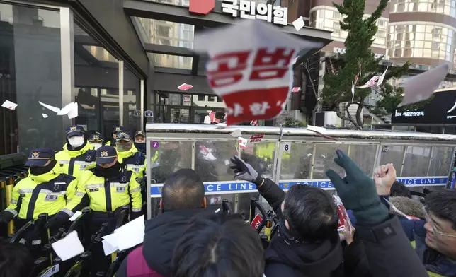 Members of the Korean Confederation of Trade Unions throw torn papers carrying the names of the ruling party's lawmakers who didn't vote at the impeachment motion last week, during a rally in front of the ruling People Power Party's head office in Seoul, South Korea, Monday, Dec. 9, 2024. (AP Photo/Lee Jin-man)