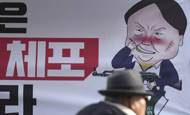 A caricature depicting South Korean President Yoon Suk Yeol is seen near the ruling People Power Party's head office in Seoul, South Korea, Monday, Dec. 9, 2024. The letters read "Arrest." (AP Photo/Lee Jin-man)