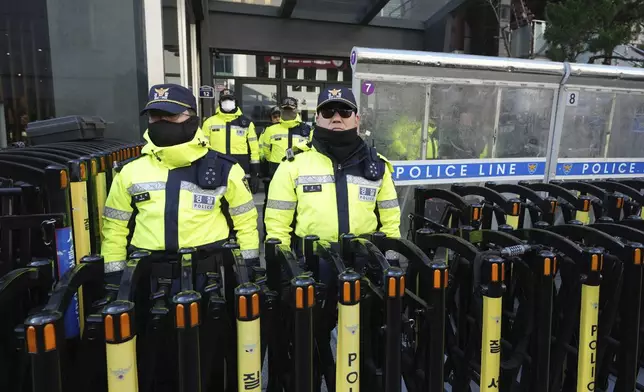 Police officers stand guard in front of the ruling People Power Party's head office in Seoul, South Korea, Monday, Dec. 9, 2024. (AP Photo/Lee Jin-man)