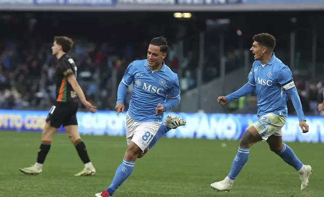 Napoli's Giacomo Raspadori, center, celebrates after scoring the opening goal during the Serie A soccer match between Napoli and Venezia at the Diego Armando Maradona Stadium in Naples, Italy Sunday Dec. 29, 2024. (Alessandro Garofalo/LaPresse via AP)