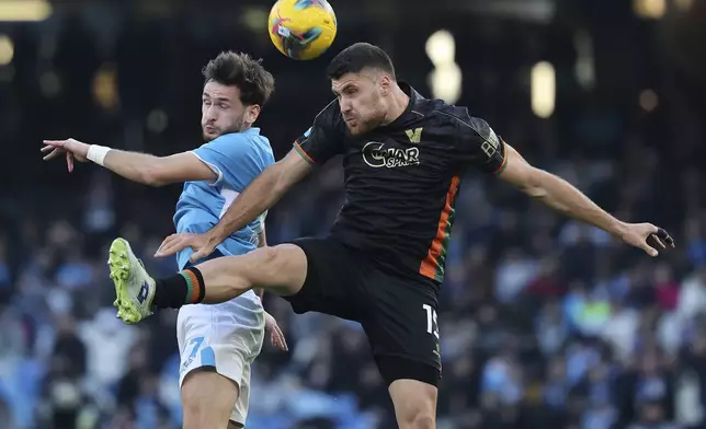 Napoli's Khvicha Kvaratskhelia, left, and Venezia's Giorgio Altare in action during the Serie A soccer match between Napoli and Venezia at the Diego Armando Maradona Stadium in Naples, Italy Sunday Dec. 29, 2024. (Alessandro Garofalo/LaPresse via AP)