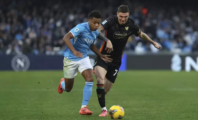 Napoli's David Neres Campos, left, and Venezia's Franco Carboni, right, in action during the Serie A soccer match between Napoli and Venezia at the Diego Armando Maradona Stadium in Naples, Italy Sunday Dec. 29, 2024. (Alessandro Garofalo/LaPresse via AP)