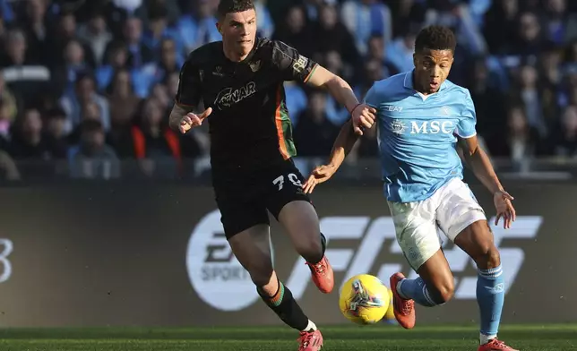 Napoli's David Neres Campos, right, and Venezia's Franco Carboni in action during the Serie A soccer match between Napoli and Venezia at the Diego Armando Maradona Stadium in Naples, Italy Sunday Dec. 29, 2024. (Alessandro Garofalo/LaPresse via AP)