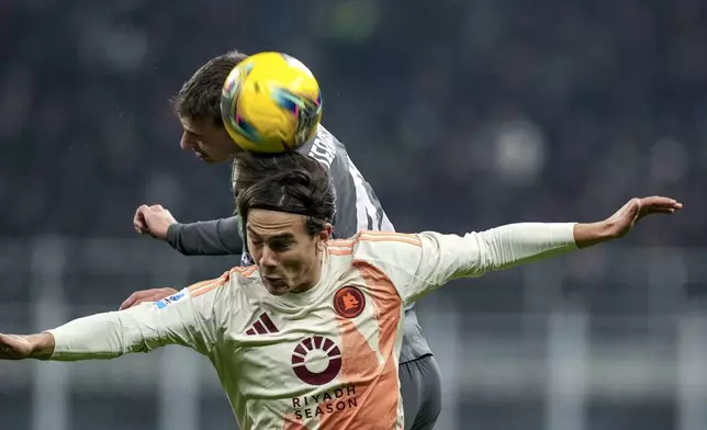 Roma's Paulo Dybala, front, jumps for the ball during the Serie A soccer match between AC Milan and Roma at the San Siro stadium, in Milan, Italy, Sunday, Dec. 29, 2024. (AP Photo/Antonio Calanni)