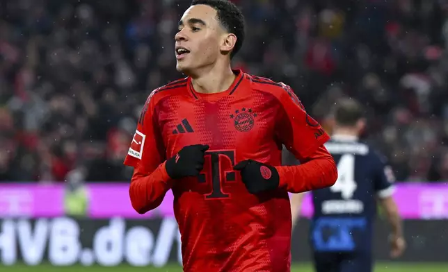 Munich's Jamal Musiala celebrates after scoring his side's fourth goal during the German Bundesliga soccer match between FC Bayern Munich and 1. FC Heidenheim 1846 in Munich, Germany, Saturday, Dec. 7, 2024. (Sven Hoppe/dpa via AP)