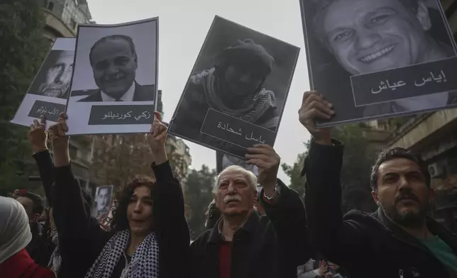 Mourners hold up portraits of missing opposition activists during the funeral of Syrian activist Mazen al-Hamada iin Damascus Thursday Dec. 12, 2024. Al-Hamad's mangled corpse was found wrapped in a bloody sheet in Saydnaya prison. He had fled to Europe but returned to Syria in 2020 and was imprisoned upon arrival. (AP Photo/Ghaith Alsayed)