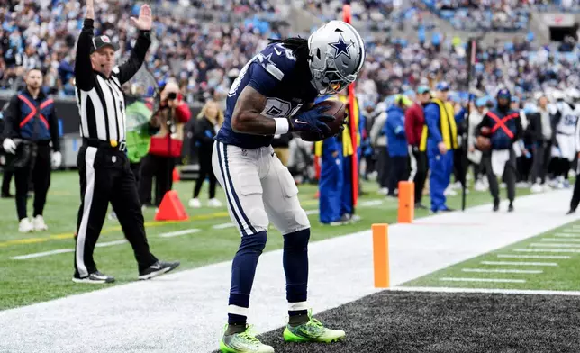 Dallas Cowboys wide receiver CeeDee Lamb celebrates after scoring against the Carolina Panthers during the first half of an NFL football game, Sunday, Dec. 15, 2024, in Charlotte, N.C. (AP Photo/Jacob Kupferman)