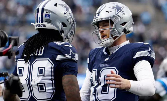 Dallas Cowboys wide receiver CeeDee Lamb celebrates after scoring with quarterback Cooper Rush against the Carolina Panthers during the first half of an NFL football game, Sunday, Dec. 15, 2024, in Charlotte, N.C. (AP Photo/Jacob Kupferman)