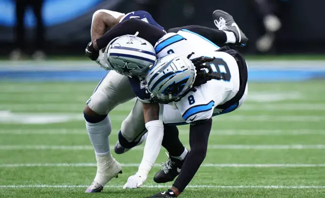 Dallas Cowboys running back Rico Dowdle is tackled by Carolina Panthers cornerback Jaycee Horn during the first half of an NFL football game, Sunday, Dec. 15, 2024, in Charlotte, N.C. (AP Photo/Jacob Kupferman)