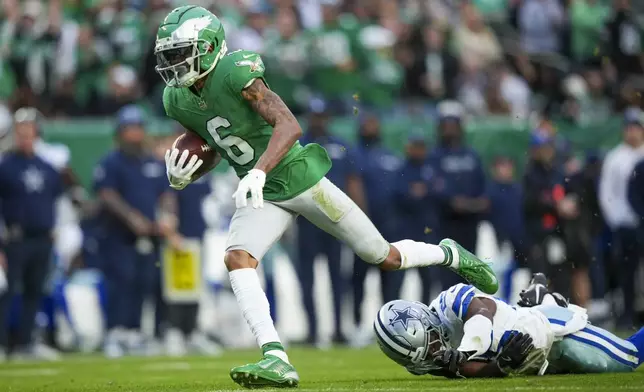 Philadelphia Eagles wide receiver DeVonta Smith (6) avoids a tackle by Dallas Cowboys cornerback Andrew Booth Jr. while scoring on a touchdown catch during the second half of an NFL football game, Sunday, Dec. 29, 2024, in Philadelphia. (AP Photo/Matt Slocum)