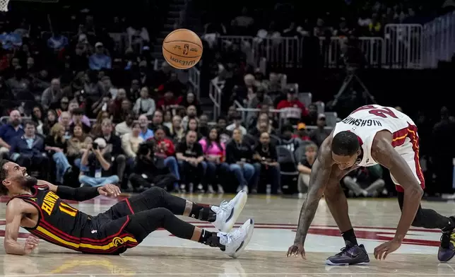 Atlanta Hawks guard Trae Young (11) and Miami Heat forward Haywood Highsmith (24) collide during the first half of an NBA basketball game, Saturday, Dec. 28, 2024, in Atlanta. (AP Photo/Mike Stewart)