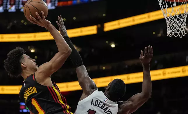 Atlanta Hawks forward Jalen Johnson (1) shoots against Miami Heat center Bam Adebayo (13) during the first half of an NBA basketball game, Saturday, Dec. 28, 2024, in Atlanta. (AP Photo/Mike Stewart)