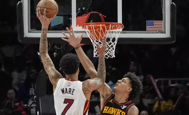 Miami Heat center Kel'el Ware (7) shoots against Atlanta Hawks forward Jalen Johnson (1) during the first half of an NBA basketball game, Saturday, Dec. 28, 2024, in Atlanta. (AP Photo/Mike Stewart)