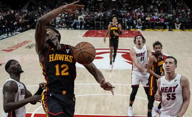 Atlanta Hawks forward De'Andre Hunter (12) dunks against the Miami Heat during the first half of an NBA basketball game, Saturday, Dec. 28, 2024, in Atlanta. (AP Photo/Mike Stewart)