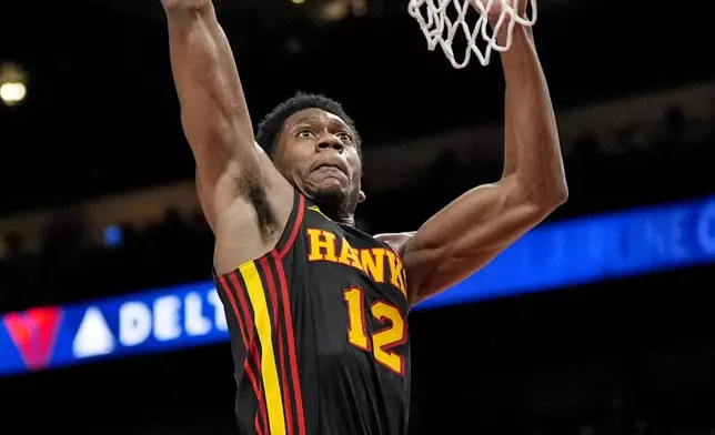 Atlanta Hawks forward De'Andre Hunter (12) goes to the hoop against the Miami Heat during the first half of an NBA basketball game, Saturday, Dec. 28, 2024, in Atlanta. (AP Photo/Mike Stewart)