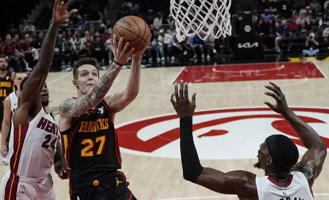 Atlanta Hawks guard Vit Krejci (27) shoots against Miami Heat forward Haywood Highsmith (24) during the first half of an NBA basketball game, Saturday, Dec. 28, 2024, in Atlanta. (AP Photo/Mike Stewart)