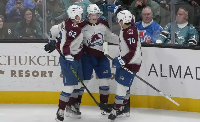 Colorado Avalanche left wing Joel Kiviranta, middle, is congratulated by left wing Artturi Lehkonen (62) and defenseman Sam Malinski (70) after scoring against the San Jose Sharks during the third period of an NHL hockey game in San Jose, Calif., Thursday, Dec. 19, 2024. (AP Photo/Jeff Chiu)