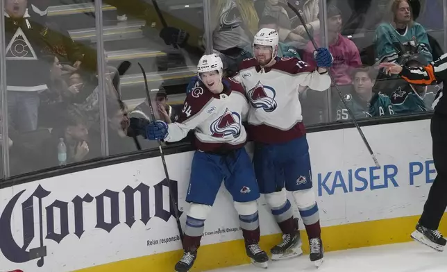 Colorado Avalanche left wing Joel Kiviranta (94) is congratulated by right wing Valeri Nichushkin (13) after scoring against the San Jose Sharks during the third period of an NHL hockey game in San Jose, Calif., Thursday, Dec. 19, 2024. (AP Photo/Jeff Chiu)