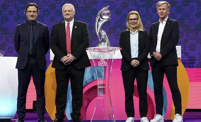 The coach of France, Laurent Bonadei, a representative of Wales, England coach Sarina Wiegman and the Netherlands coach Andries Jonker, from left, pose with the tournament trophy at the end of the UEFA Euro 2025 European women's soccer championship final draw at the Swiss Tech Convention Centre in Lausanne, Switzerland, Monday, Dec. 16, 2024. (AP Photo/Laurent Cipriani)