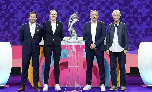 The coaches of Finland Marko Saloranta, Norway Gemma Grainger, Iceland Thorsteinn Halldorsson and Switzerland Pia Sundhage, from left, pose with the tournament trophy at the end of the UEFA Euro 2025 European women's soccer championship final draw at the Swiss Tech Convention Centre in Lausanne, Switzerland, Monday, Dec. 16, 2024. (AP Photo/Laurent Cipriani)