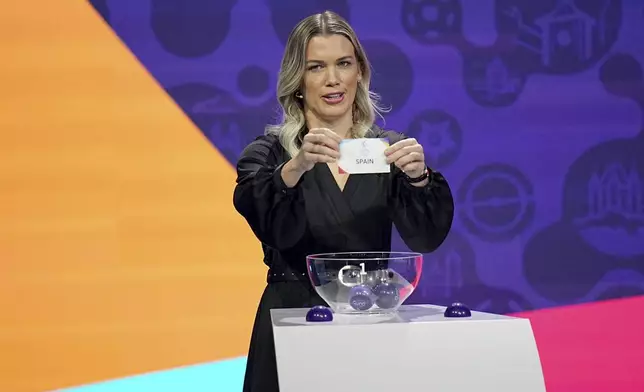 Swiss former soccer player Lara Dickenmann draws Spain during the UEFA Euro 2025 European women's soccer championship final draw at the Swiss Tech Convention Centre in Lausanne, Switzerland, Monday, Dec. 16, 2024. (AP Photo/Laurent Cipriani)