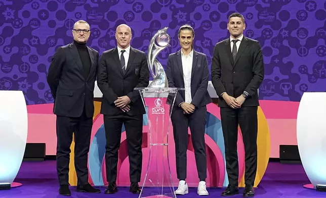 The coaches of Belgium Ives Serneels, Italy Andrea Soncin, Spain Montserrat Tome and Portugal Francisco Neto, from left, pose with the tournament trophy at the end of the UEFA Euro 2025 European women's soccer championship final draw at the Swiss Tech Convention Centre in Lausanne, Switzerland, Monday, Dec. 16, 2024. (AP Photo/Laurent Cipriani)