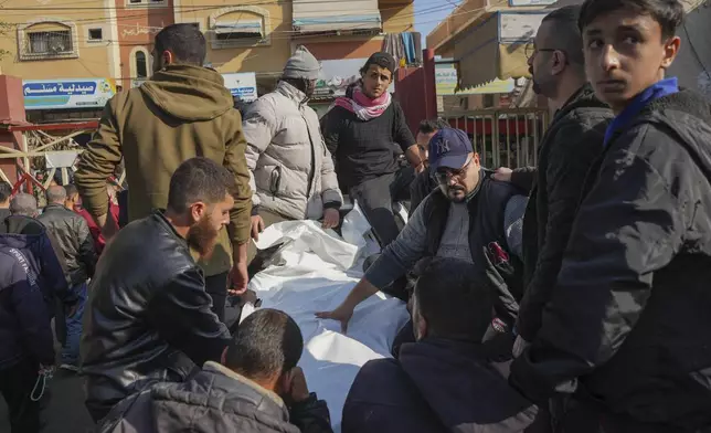 The bodies of civilian victims of an overnight Israeli army airstrike on the Nuseirat refugee camp arrive at the Al-Aqsa Martyrs hospital in Deir al-Balah, Gaza Strip, Thursday Dec. 12, 2024. Palestinian medical officials say Israeli airstrikes have killed at least 28 people in the Gaza Strip, including seven children and a woman. (AP Photo/Abdel Kareem Hana)