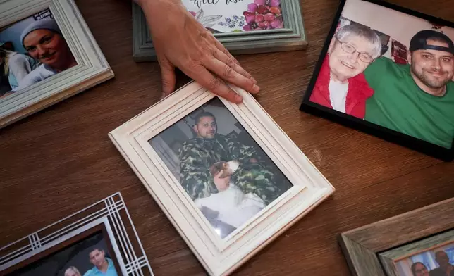 Jen Dold, whose brother, Alex Dold, lived with schizophrenia and died after a 2017 encounter with sheriff's deputies and police officers, displays family photos of her brother Wednesday, Sept. 18, 2024, at her home in Edmonds, Wash. (AP Photo/Lindsey Wasson)