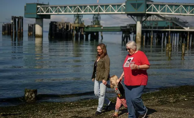 Jen Dold, whose brother, Alex Dold, lived with schizophrenia and died after a 2017 encounter with sheriff's deputies and police officers, walks with her niece, Alena Alexandra Judy, 4, and Jen and Alex's mother, Kathy Duncan, right, Wednesday, Sept. 18, 2024, on the waterfront in Edmonds, Wash. (AP Photo/Lindsey Wasson)