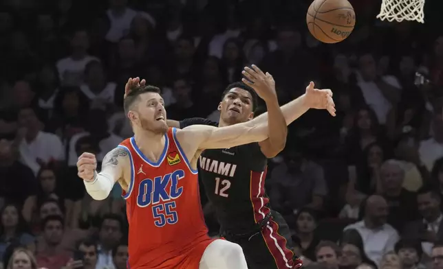 Oklahoma City Thunder center Isaiah Hartenstein (55) slaps the ball away from Miami Heat guard Dru Smith (12) during the second half of an NBA basketball game, Friday, Dec. 20, 2024, in Miami. (AP Photo/Marta Lavandier)