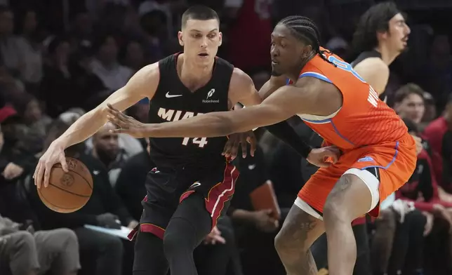 Oklahoma City Thunder forward Jalen Williams (8) defends Miami Heat guard Tyler Herro (14) during the second half of an NBA basketball game, Friday, Dec. 20, 2024, in Miami. (AP Photo/Marta Lavandier)