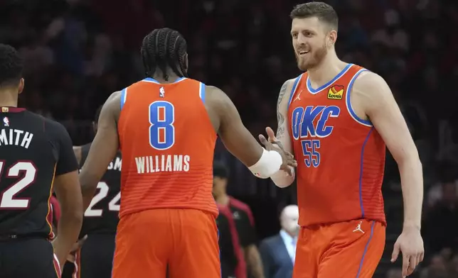 Oklahoma City Thunder forward Jalen Williams (8) and center Isaiah Hartenstein (55) celebrate during a timeout during the second half of an NBA basketball game against the Miami Heat, Friday, Dec. 20, 2024, in Miami. (AP Photo/Marta Lavandier)