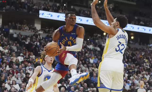 Denver Nuggets guard Russell Westbrook, front left, drives past Golden State Warriors guard Brandin Podziemski, back left, and forward Trayce Jackson-Davis to pass the ball in the first half of an Emirates NBA Cup basketball game Tuesday, Dec. 3, 2024, in Denver. (AP Photo/David Zalubowski)