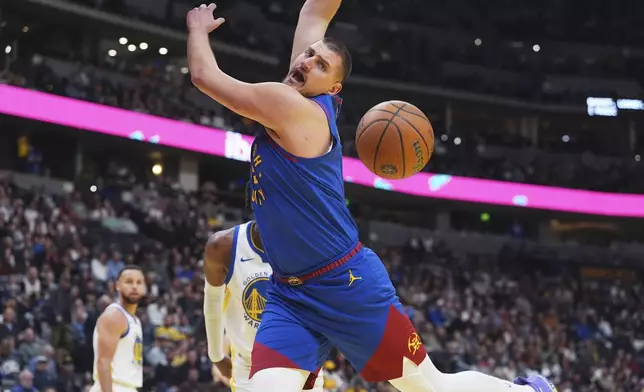 Denver Nuggets center Nikola Jokic, front, reacts after he was fouled by Golden State Warriors forward Kevon Looney in the first half of an Emirates NBA Cup basketball game Tuesday, Dec. 3, 2024, in Denver. (AP Photo/David Zalubowski)