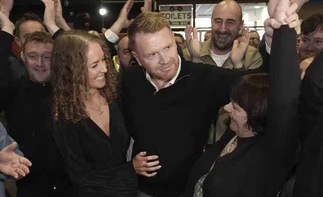 Social Democrats Gary Gannon celebrates being elected along with wife Clodagh Allen and mother Tina Gannon at RDS Simmonscourt, Dublin, as the election count continues in Ireland's election, in Dublin, Sunday Dec. 1, 2024. (Brian Lawless/PA via AP)