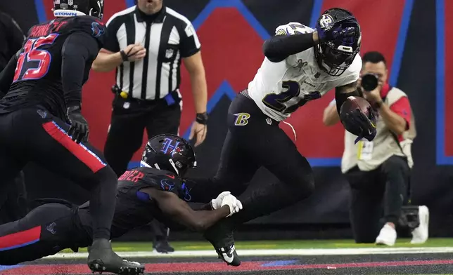 Baltimore Ravens running back Derrick Henry, right, is tackled by Houston Texans cornerback Kamari Lassiter for a safety during the first half of an NFL football game, Wednesday, Dec. 25, 2024, in Houston. (AP Photo/David J. Phillip)