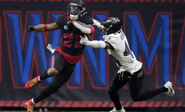 Houston Texans running back Joe Mixon (28) catches a pass in front of Baltimore Ravens cornerback Marlon Humphrey (44) during the first half of an NFL football game, Wednesday, Dec. 25, 2024, in Houston. (AP Photo/Eric Christian Smith)